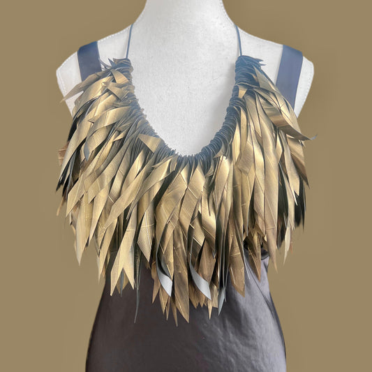 A gold painted rubber necklace worn in a longer length on a mannequin