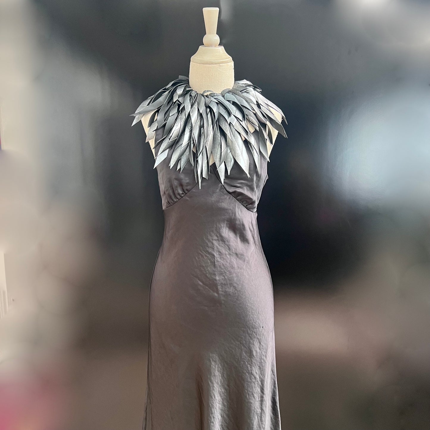 A mannequin wears a hand painted large grey silver rubber necklace