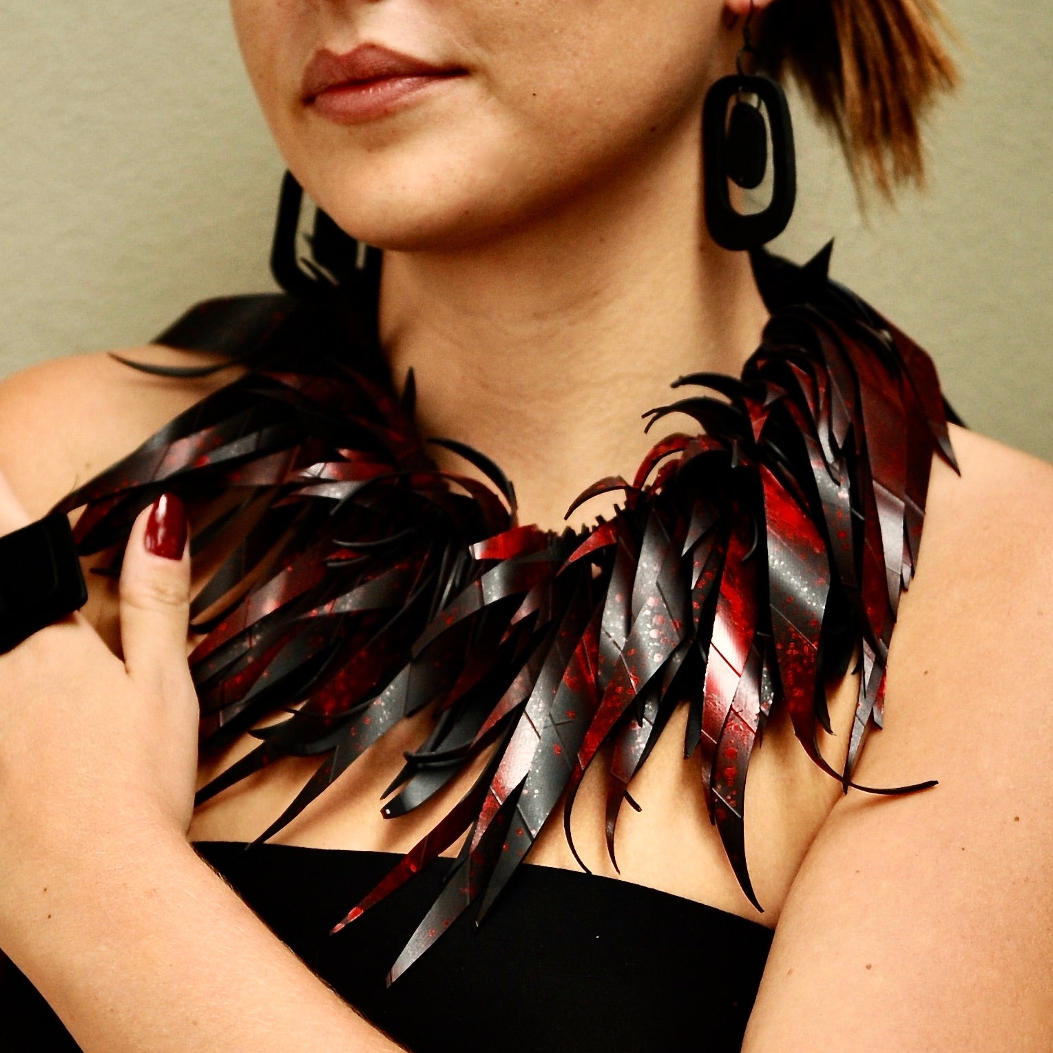 A woman wears a red rubber necklace