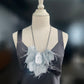 A mannequin wears a silver bouncy necklace