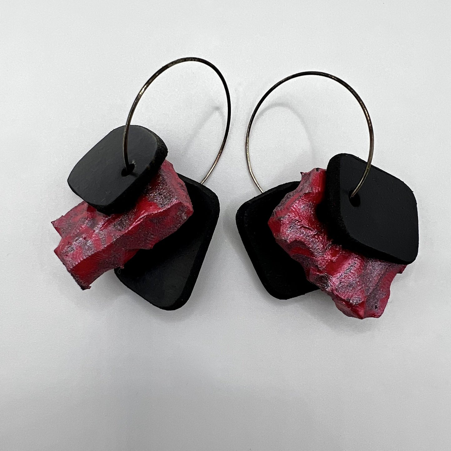 A pair of rubber and painted rubber earrings on silver hoops