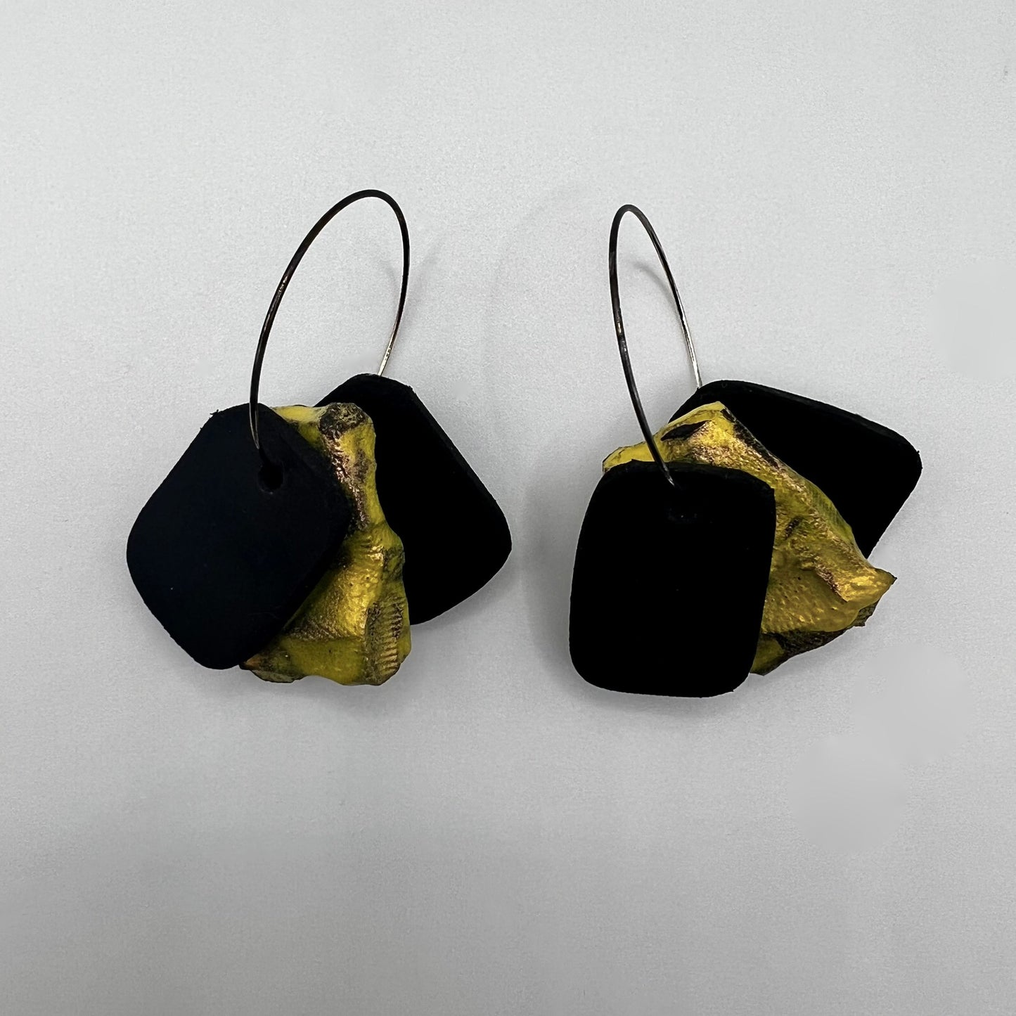 A pair of rubber and painted rubber earrings on silver hoops