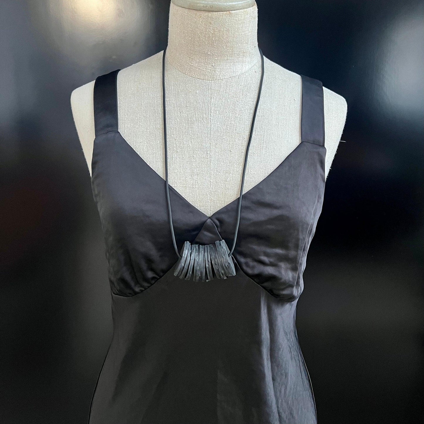 A mannequin wears a necklace with small circles bunched together