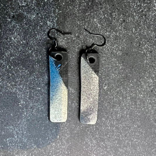 A pair of rubber earrings with spray painted blue and silver colour