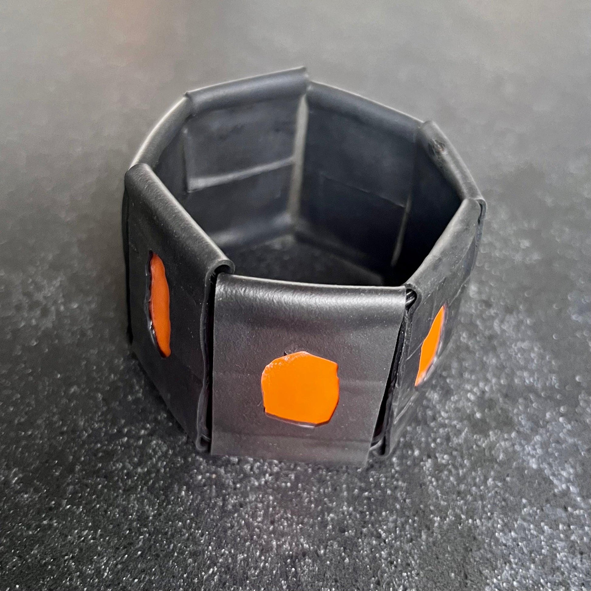 A large rubber and orange plastic bracelet