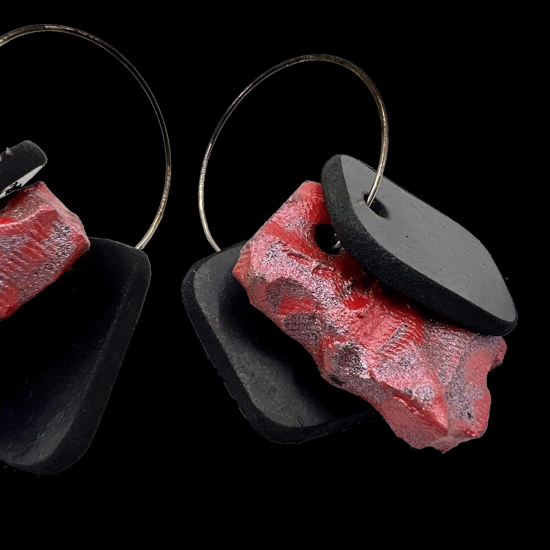 Close up of a pair of earrings with black rubber and painted rubber