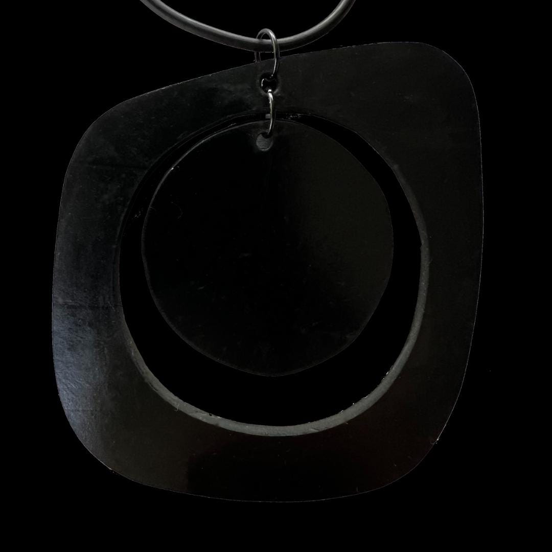 A rubber round-like pendant on a necklace