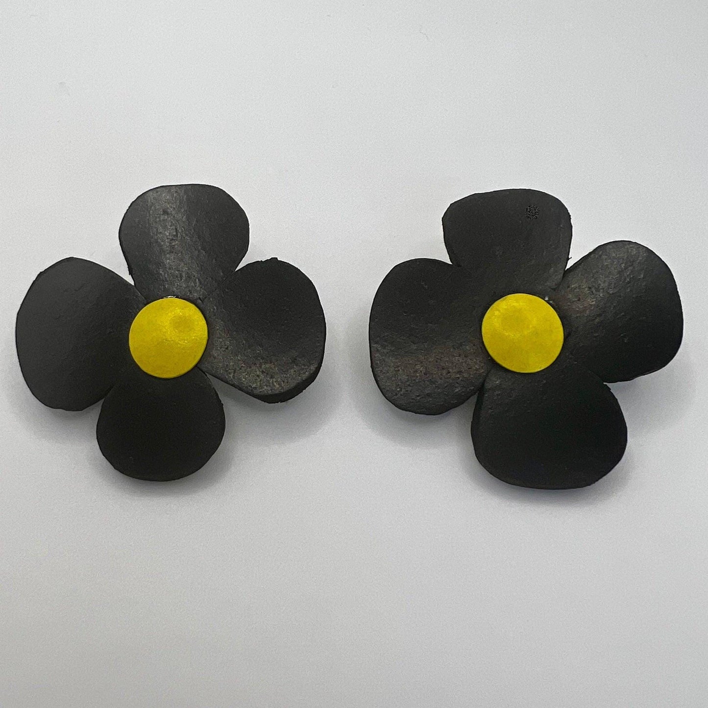 A pair of rubber black and yellow daisy earrings