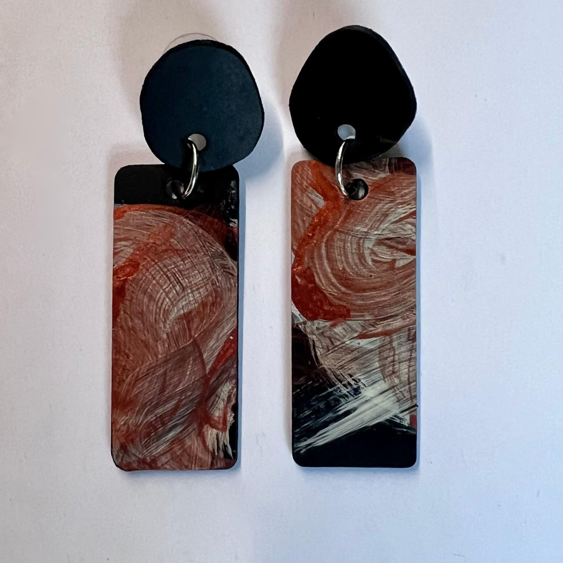 A pair of long rectangle earrings with abstract metallic painted surface