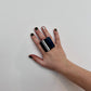 A woman&#39;s hand wearing a large repurposed rubber ring with a GT stripe