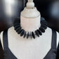 A mannequin wears a choker of rubber circles