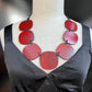 A mannequin wears a red painted rubber necklace