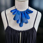 A mannequin wears a blue painted rubber necklace worn as a choker