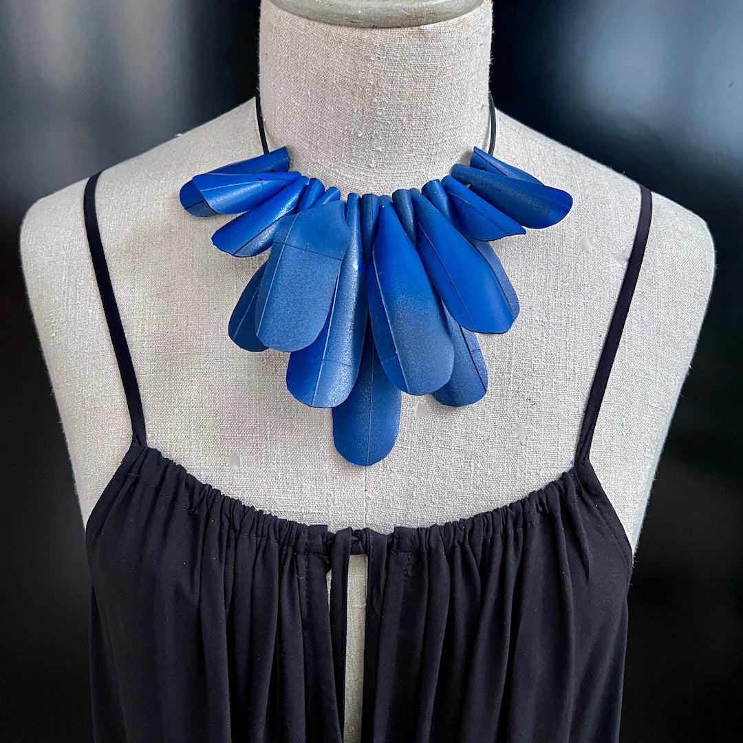 A mannequin wears a blue painted rubber necklace worn as a choker