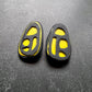 A pair of black rubber and yellow plastic stud earrings