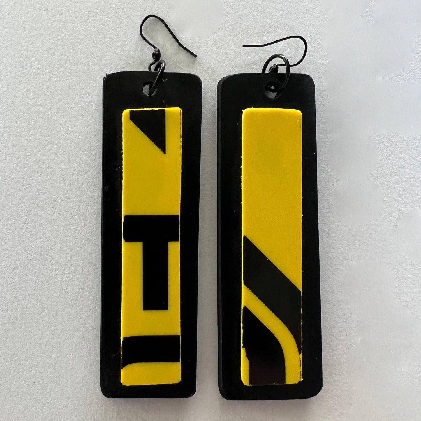 A pair of long yellow and black earrings