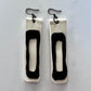 A pair of black and white long rubber earrings