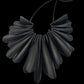 A necklace made up of pieces of bicycle inner tube that resembles a flower with no background