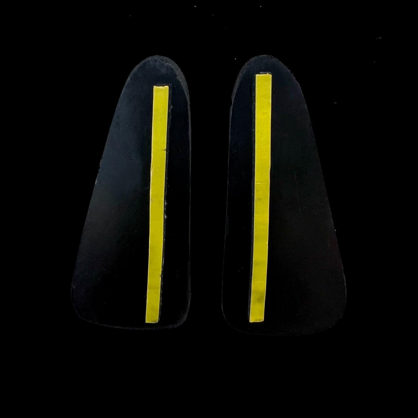 A pair of black rubber earrings with a single stroke of yellow