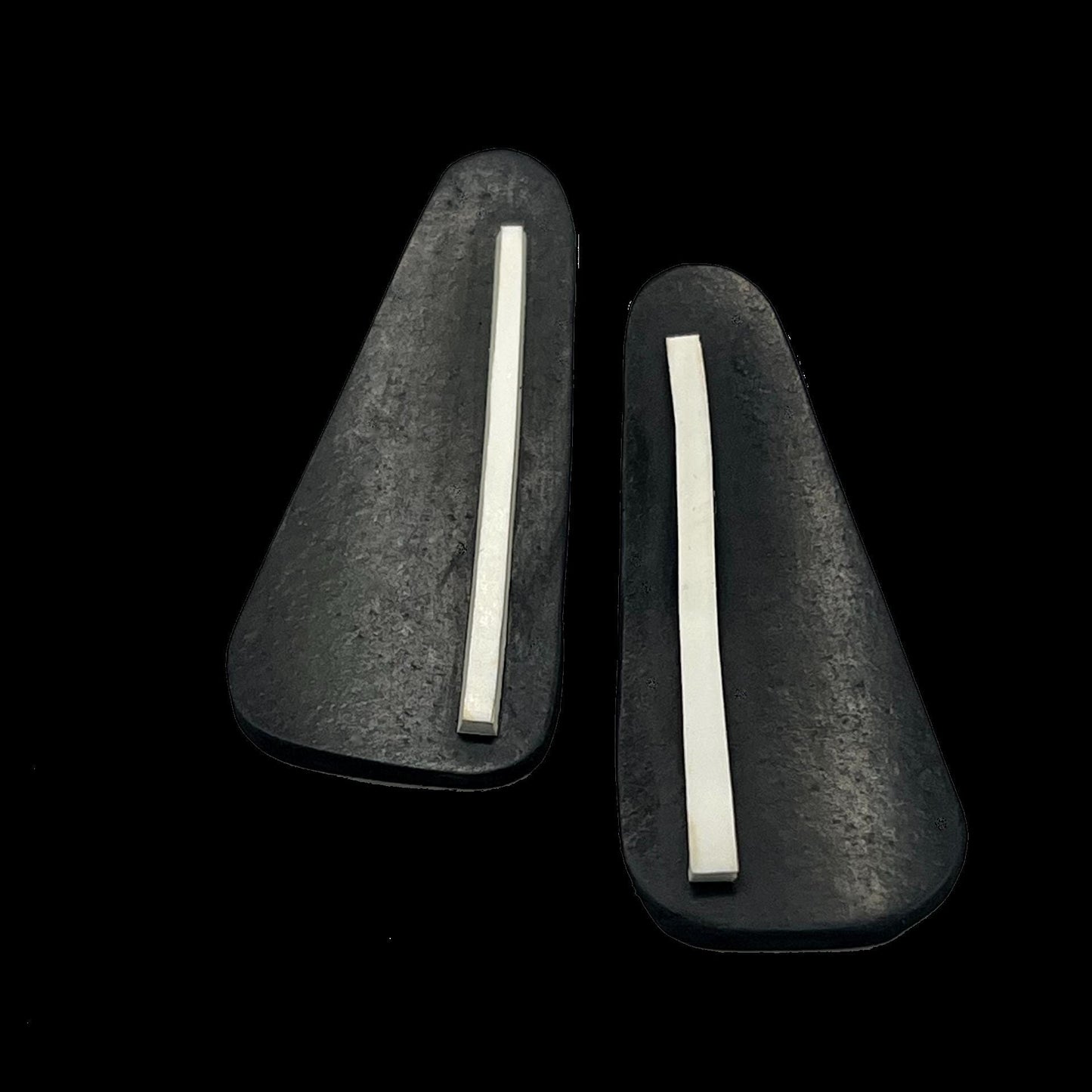 A pair of black and white rubber triangular earrings