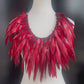 A mannequin displays a large red voluminous necklace
