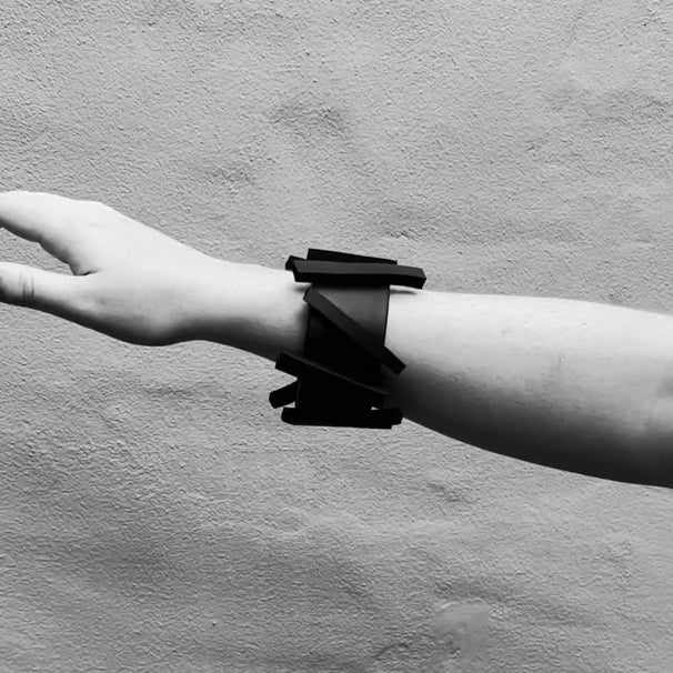 A woman waves her hand wearing a black rubber bangle