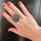 A woman waves her hand wearing a ring of repurposed black rubber