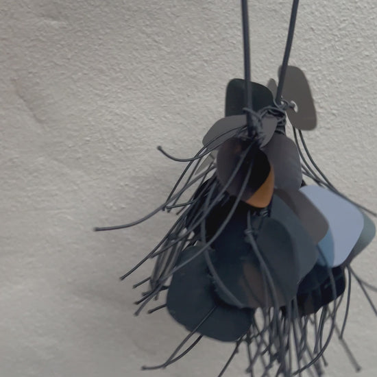 A necklace made from  black plastic necklace made from x-rays spins in the sunlight