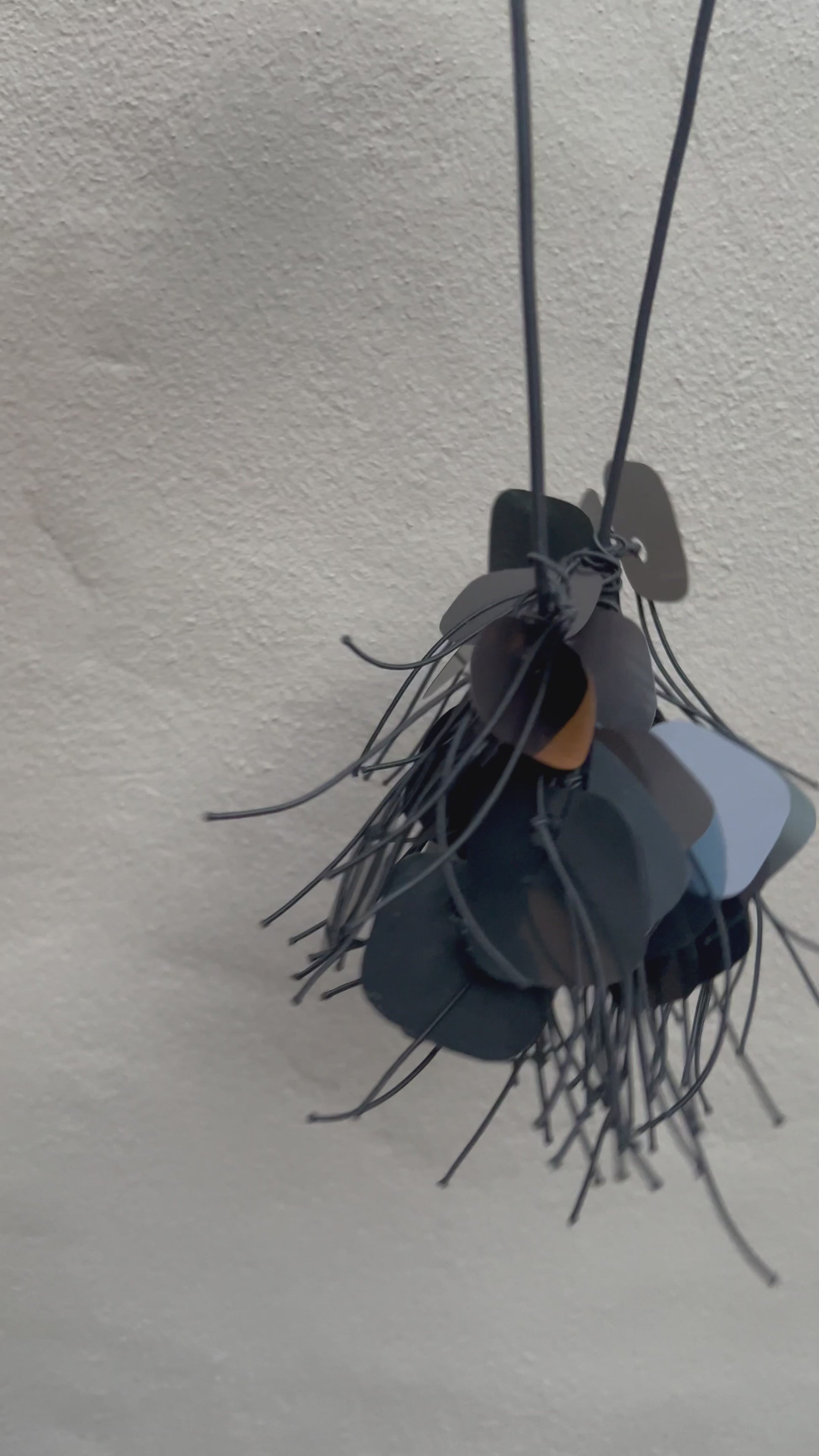 A necklace made from  black plastic necklace made from x-rays spins in the sunlight