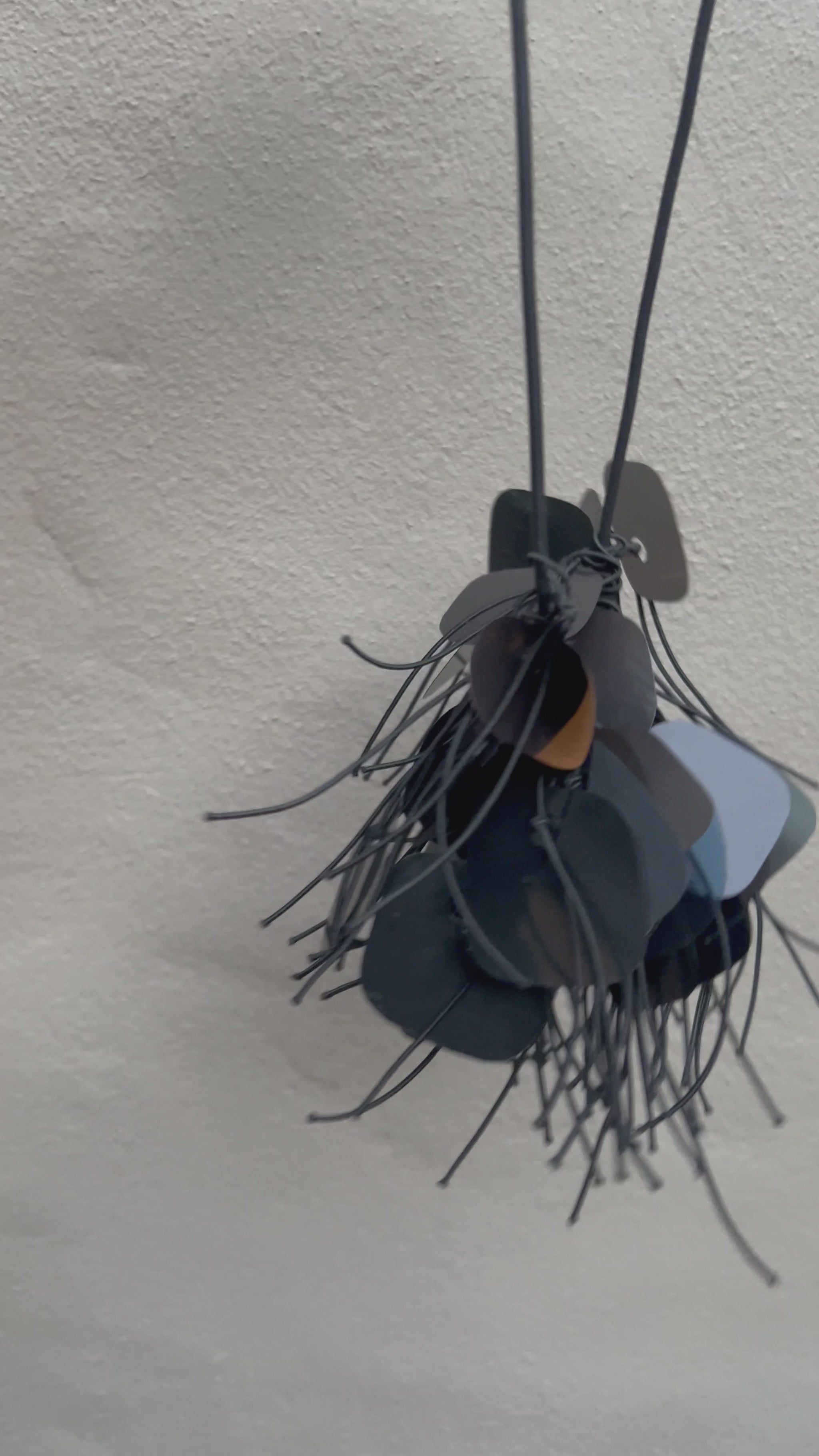 A necklace made from  black plastic necklace made from x-rays spins in the sunlight