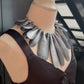 A mannequin wears a large necklace with long silver leaves