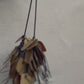 A necklace made from recycle bronze coloured plastic spins in the sunlight