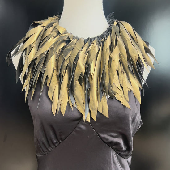 A mannequin wears a gold painted rubber necklace