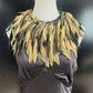 A mannequin wears a gold painted rubber necklace