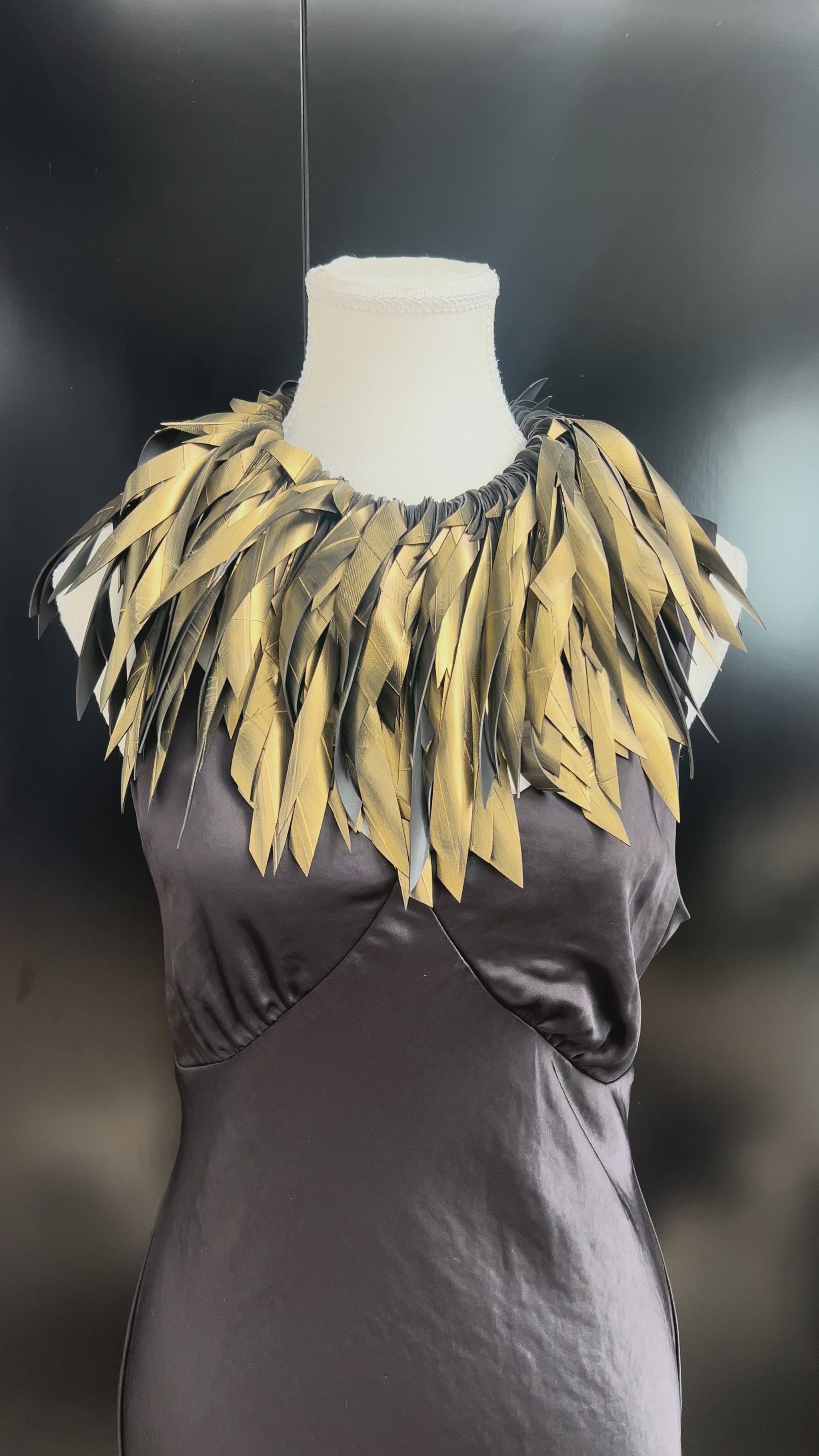 A mannequin wears a gold painted rubber necklace